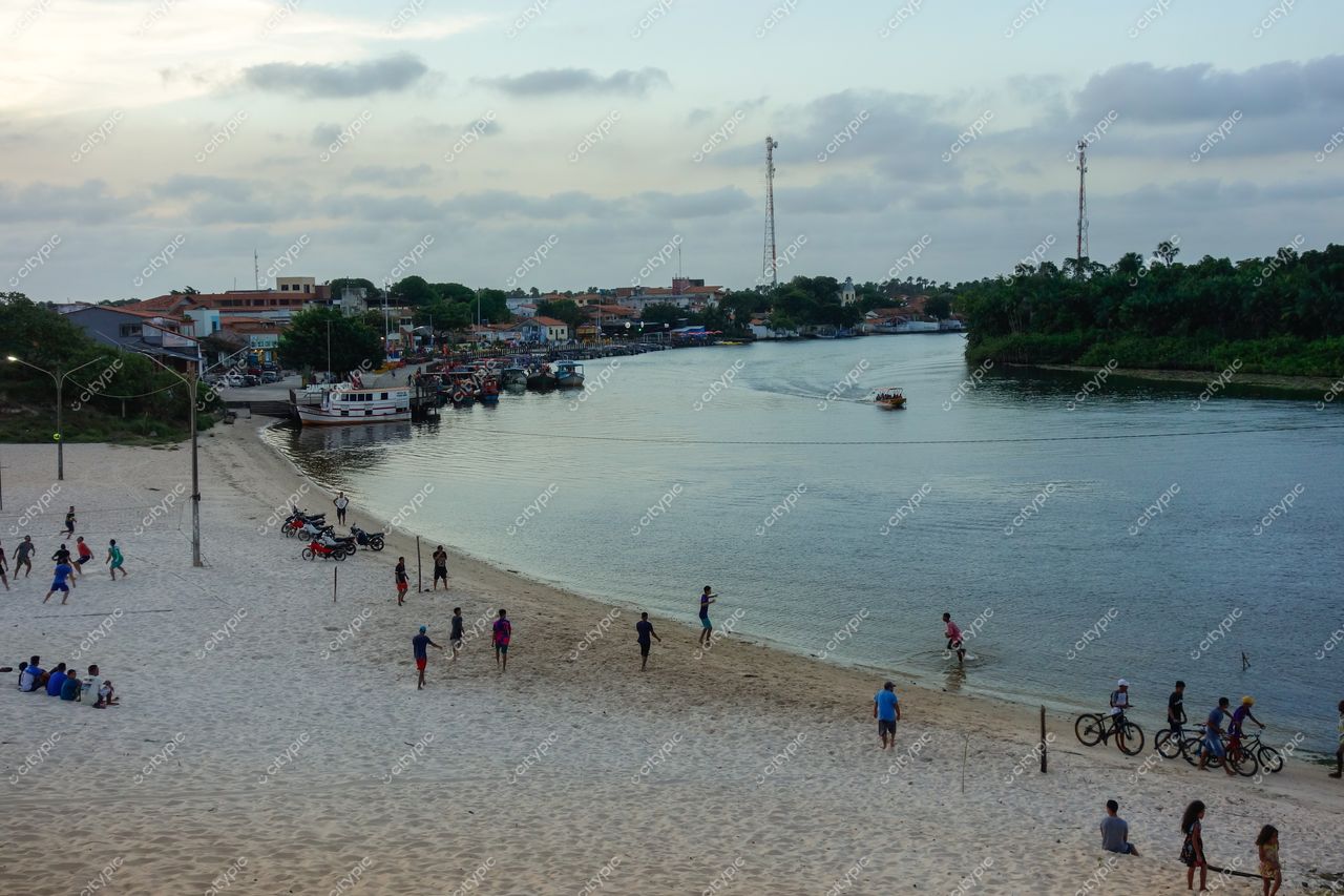 Barreirinhas, Maranhão, margem do rio com praia de areia clara e pessoas se divertindo ao entardecer