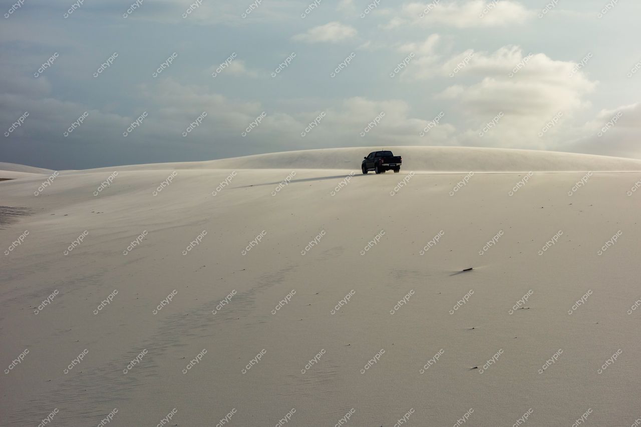 Lençóis Maranhenses, Maranhão, carro off-road preto em dunas de areia branca sob céu claro e nuvens dispersas