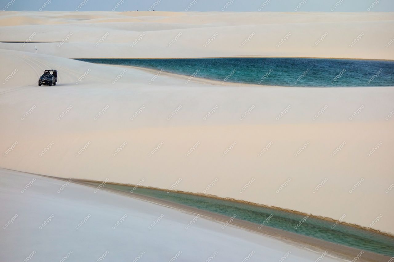 Lençóis Maranhenses, Maranhão, veículo off-road nas dunas com lagoas azuis ao entardecer e iluminação suave
