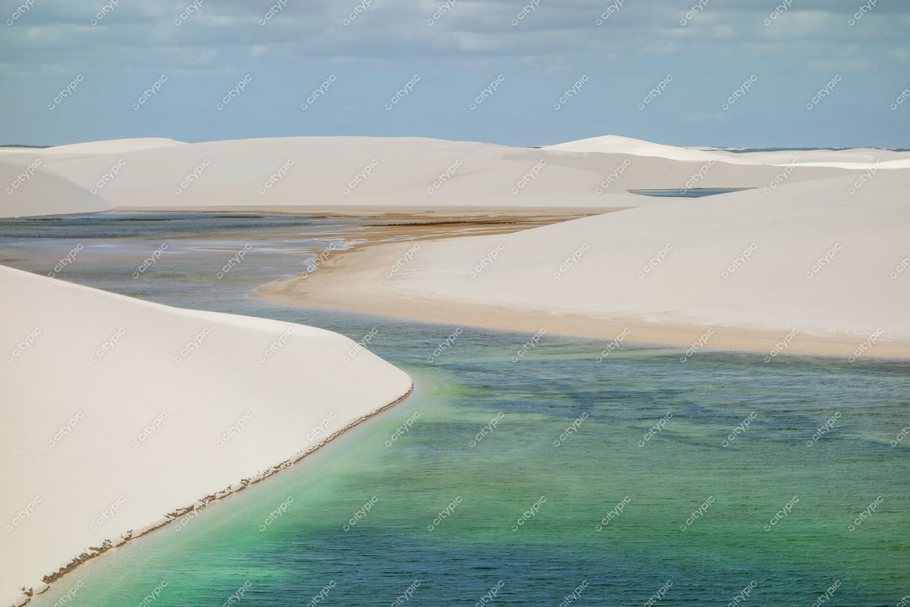 Lençóis Maranhenses, Maranhão, vastas dunas brancas com águas verdes e azuis sob céu claro e nuvens dispersas