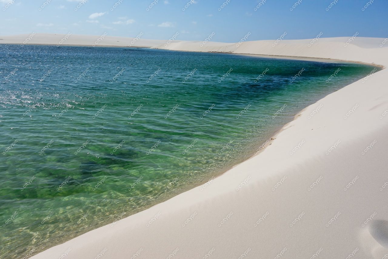 Lençóis Maranhenses, Maranhão, lago de águas cristalinas cercado por dunas brancas sob céu claro e ensolarado