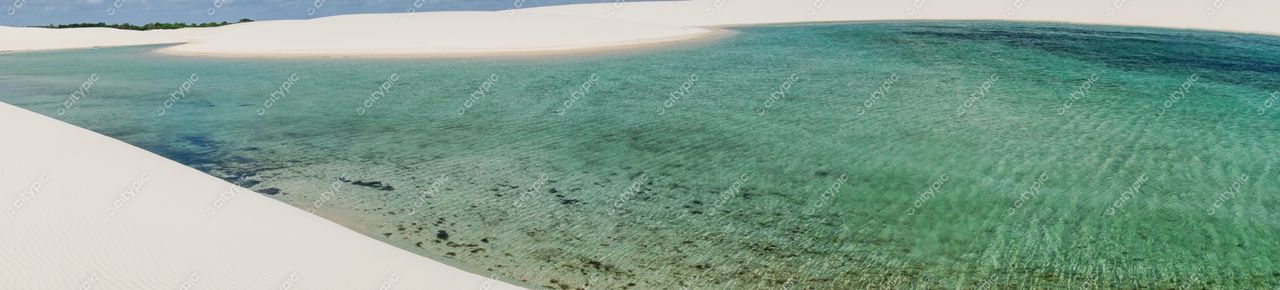 Lençóis Maranhenses, Maranhão, vista diurna com lago verde-turquesa e dunas de areia branca iluminadas pelo sol