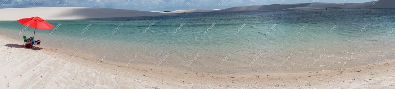 Lençóis Maranhenses, Maranhão, lago azul sob céu com nuvens e cadeira de praia verde na areia branca