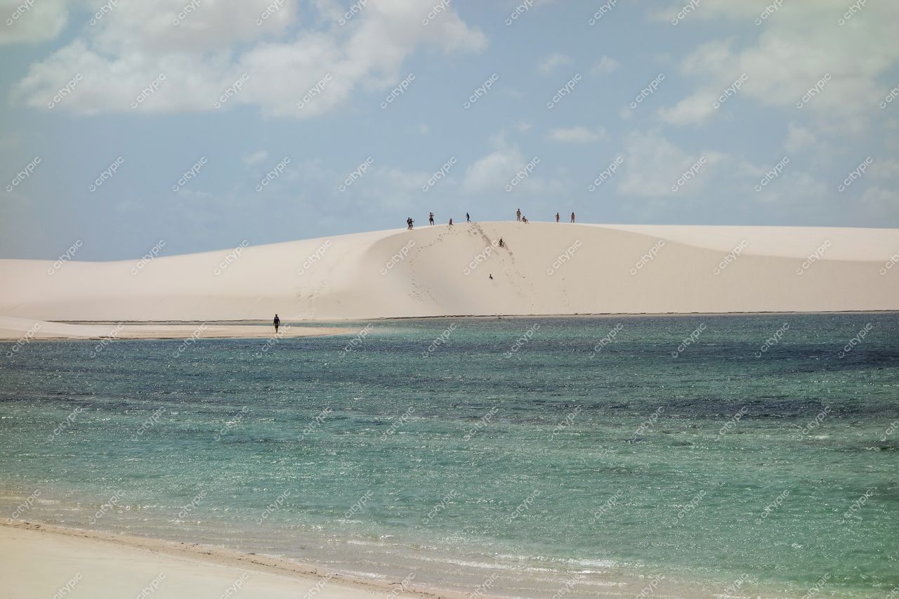 Lençóis Maranhenses, Maranhão, vista das dunas brancas com águas cristalinas e pessoas explorando em dia ensolarado
