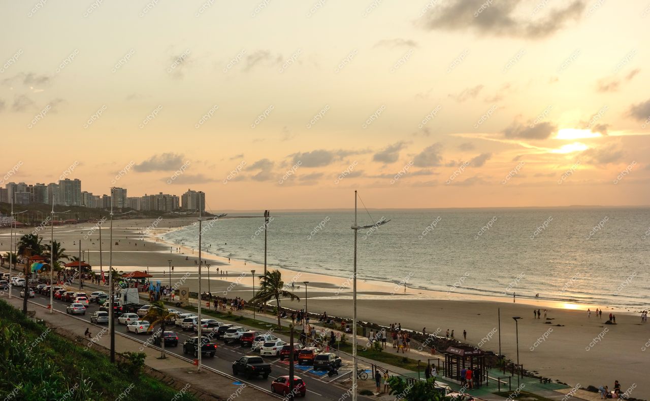 São Luís, Maranhão vista da praia ao pôr do sol com prédios modernos, vegetação e orla movimentada