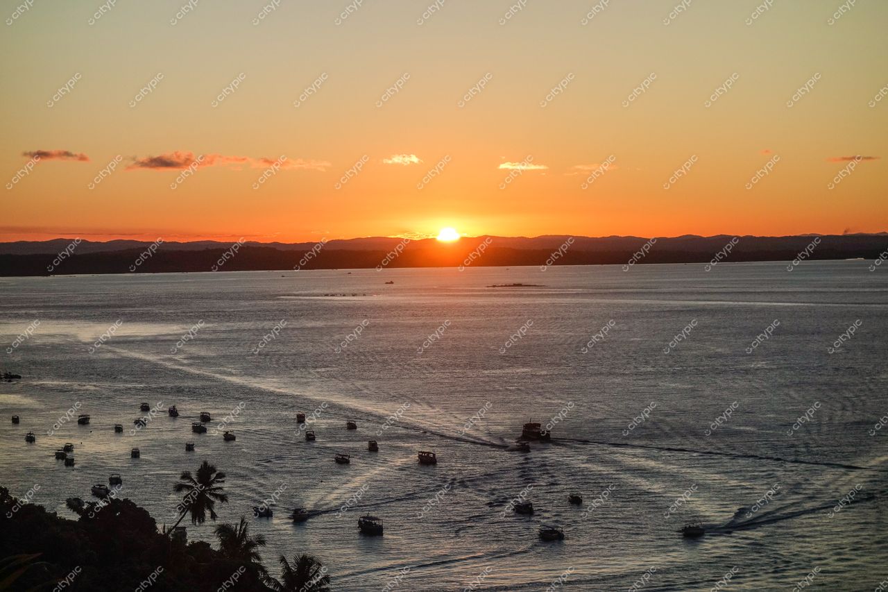 Morro de São Paulo, Bahia captura pôr do sol com reflexos laranja em águas tranquilas e vegetação tropical