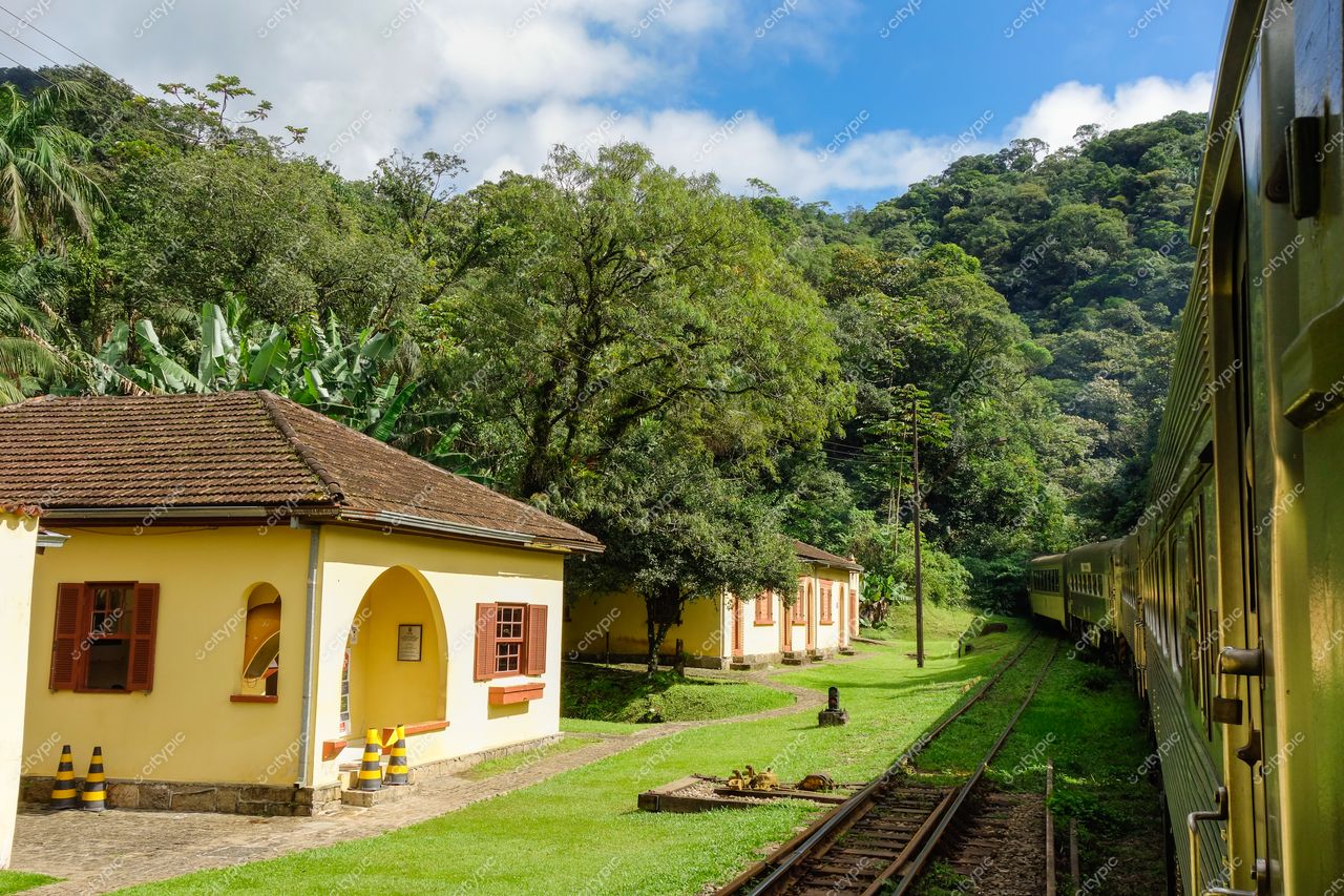 Morretes, Paraná, estação de trem com arquitetura simples em tons amarelo e terracota cercada por vegetação abundante