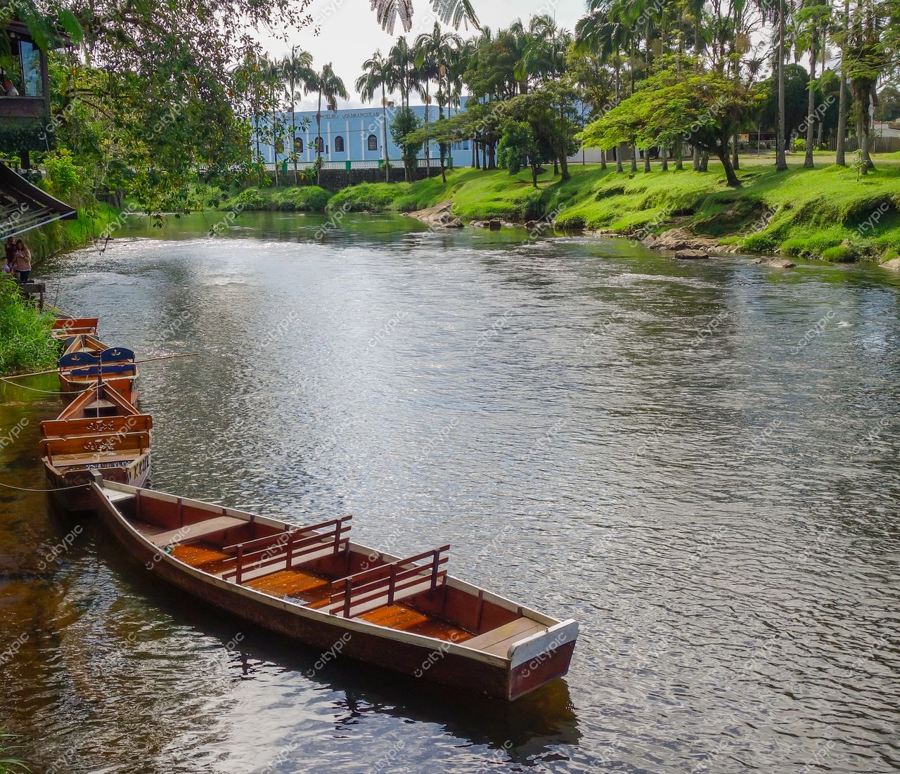 Morretes, Paraná, canoas de madeira ancoradas em rio com vegetação exuberante e arquitetura simples ao fundo