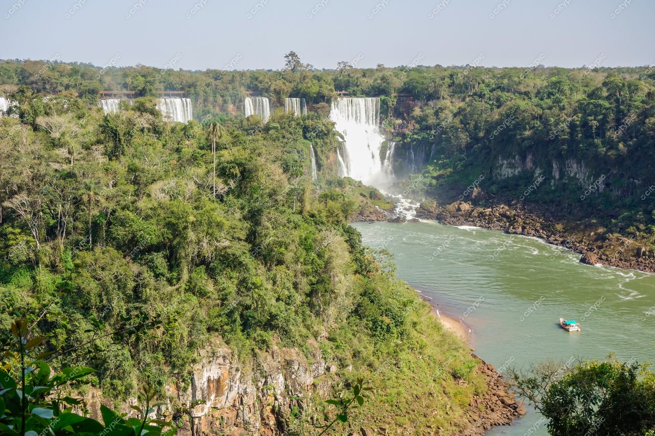 Foz do Iguaçu, Paraná vista panorâmica das Cataratas com vegetação densa e barco navegando em luz diurna