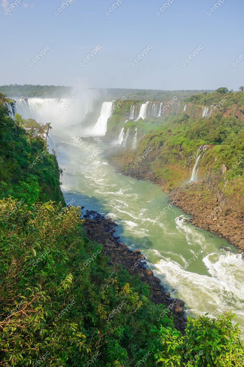 Foz do Iguaçu, Paraná, Cataratas do Iguaçu em dia claro com vegetação densa e montanhas ao fundo
