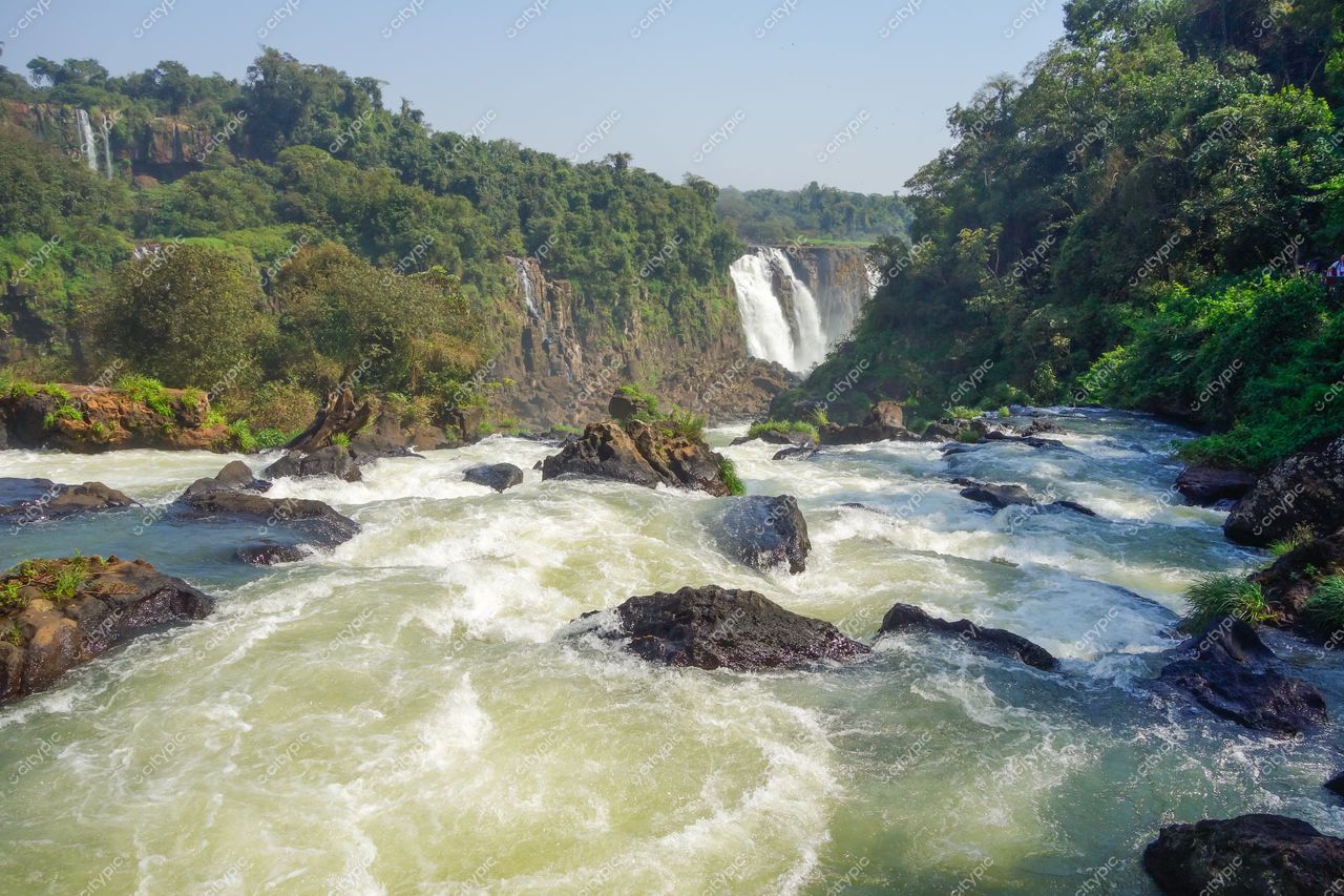 Foz do Iguaçu, Paraná vista das Cataratas com vegetação densa e rochas escuras em dia ensolarado