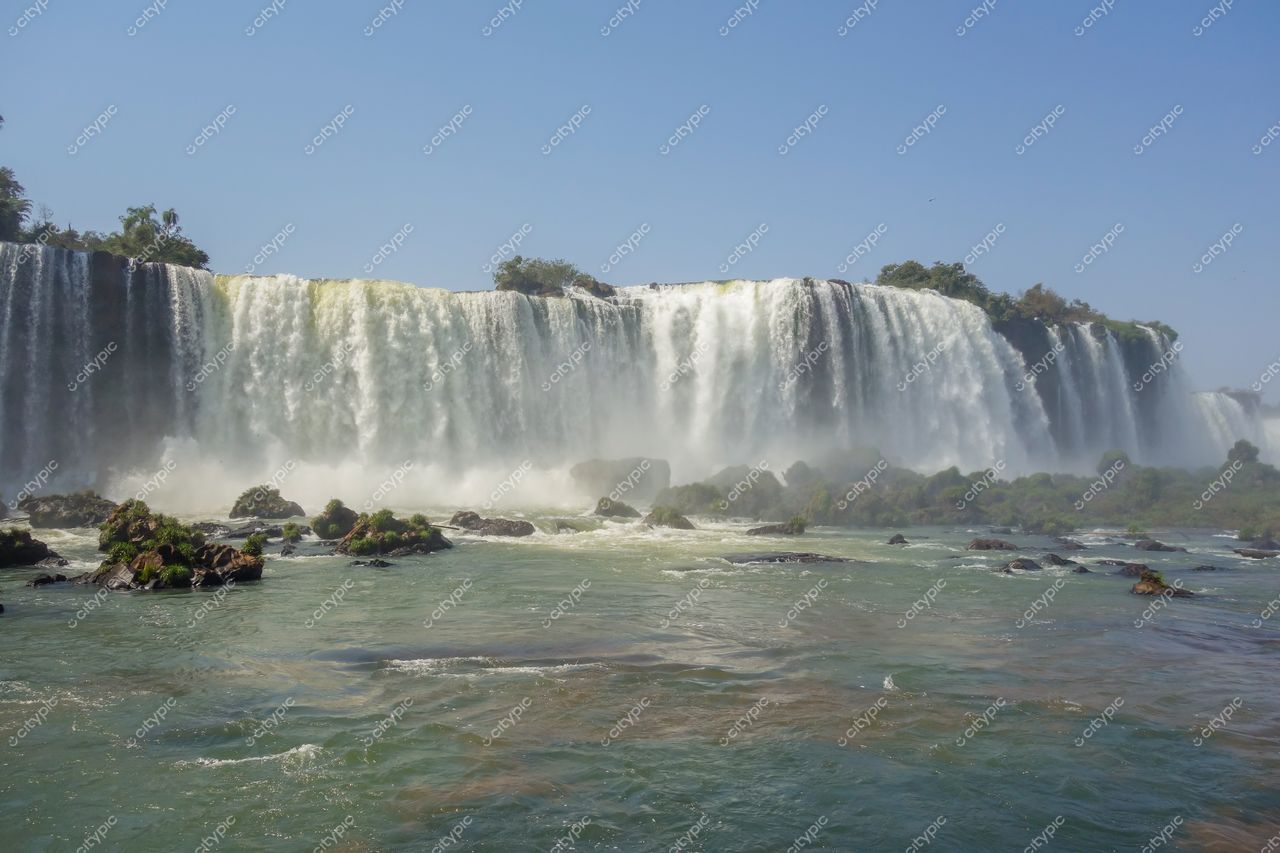 Foz do Iguaçu, Paraná em dia ensolarado com vegetação nativa e névoa das Cataratas em destaque