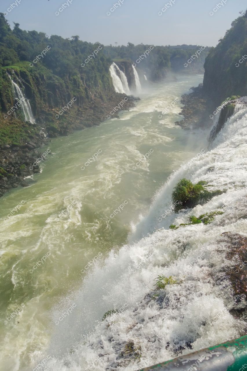 Foz do Iguaçu, Paraná, vista das Cataratas com céu claro e vegetação exuberante ao redor das quedas d’água