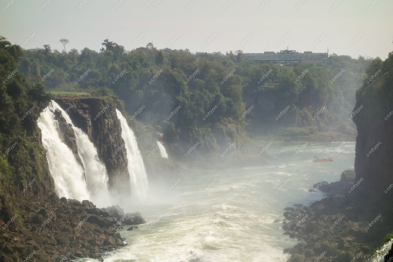 Foz do Iguaçu, Paraná, Cataratas com vegetação densa e edificação turística ao fundo em iluminação diurna suave