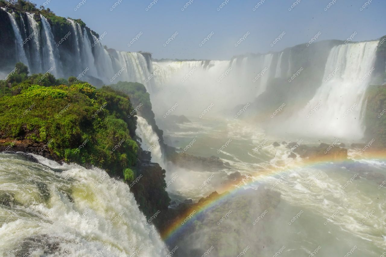 Foz do Iguaçu, Paraná vista das Cataratas com vegetação exuberante e arco-íris sob luz diurna e névoa