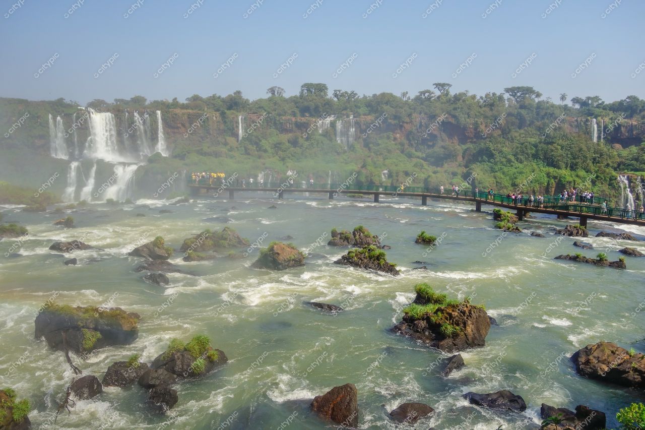 Foz do Iguaçu, Paraná, vista das Cataratas com passarela de madeira e visitantes em dia ensolarado e claro