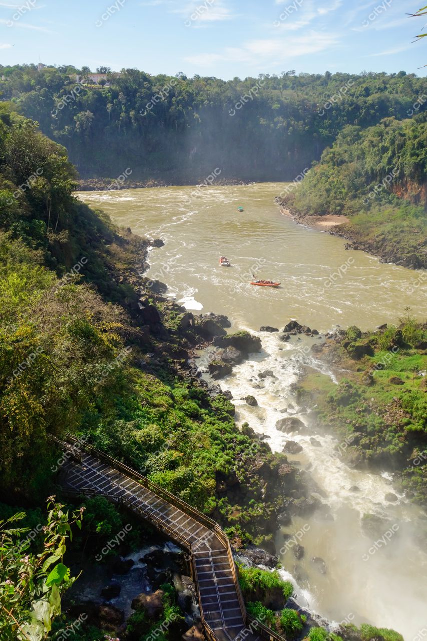 Foz do Iguaçu, Paraná vista panorâmica do Rio Iguaçu com passarela de madeira e vegetação densa sob céu ensolarado