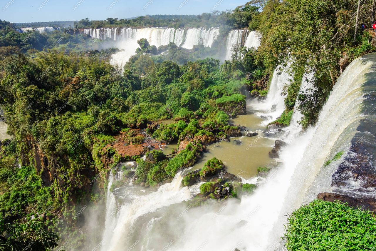 Foz do Iguaçu, Paraná, Cataratas do Iguaçu em dia ensolarado com vegetação densa e quedas d’água em destaque