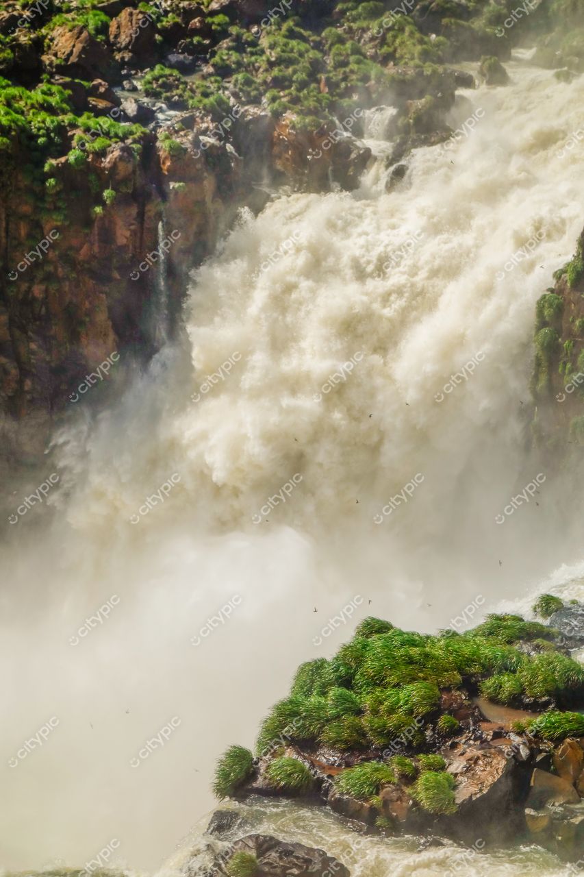 Foz do Iguaçu, Paraná, cascata poderosa em dia ensolarado com vegetação verdejante e nuvens de névoa ao redor