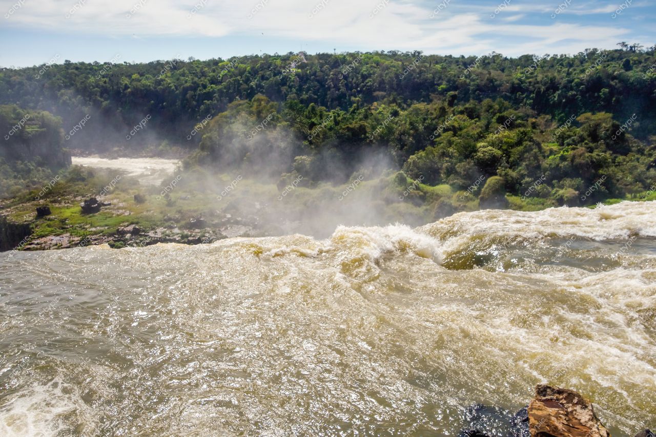 Foz do Iguaçu, Paraná vista das cataratas com névoa intensa e vegetação exuberante sob iluminação natural clara
