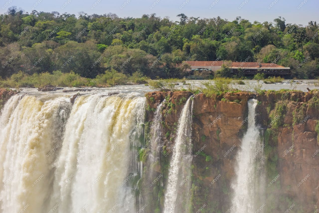 Foz do Iguaçu, Paraná, captura das Cataratas com vegetação densa e construção turística em dia ensolarado