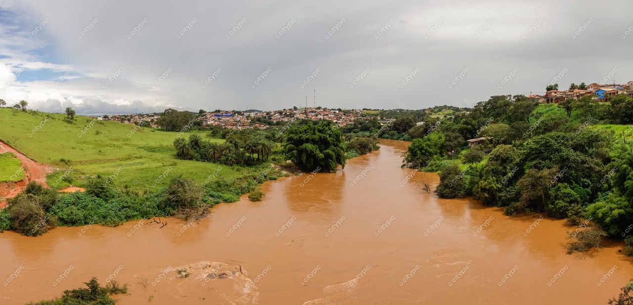 Brumadinho, Minas Gerais vista panorâmica do rio com tonalidade terrosa e vegetação exuberante sob céu nublado