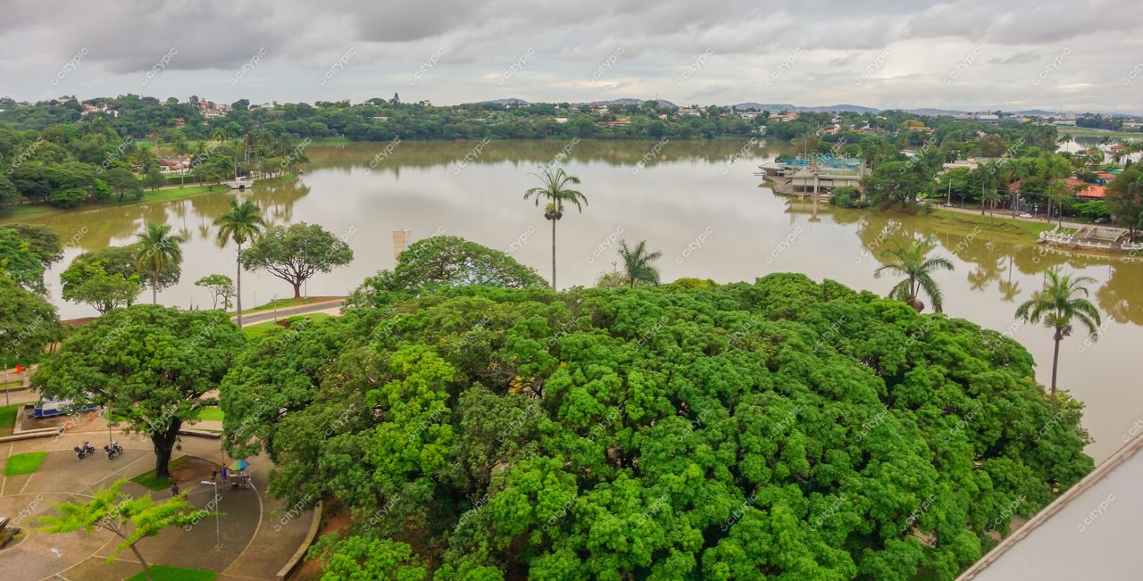 Belo Horizonte, Minas Gerais, vista ampla de lago com vegetação exuberante e residências ao fundo em dia nublado