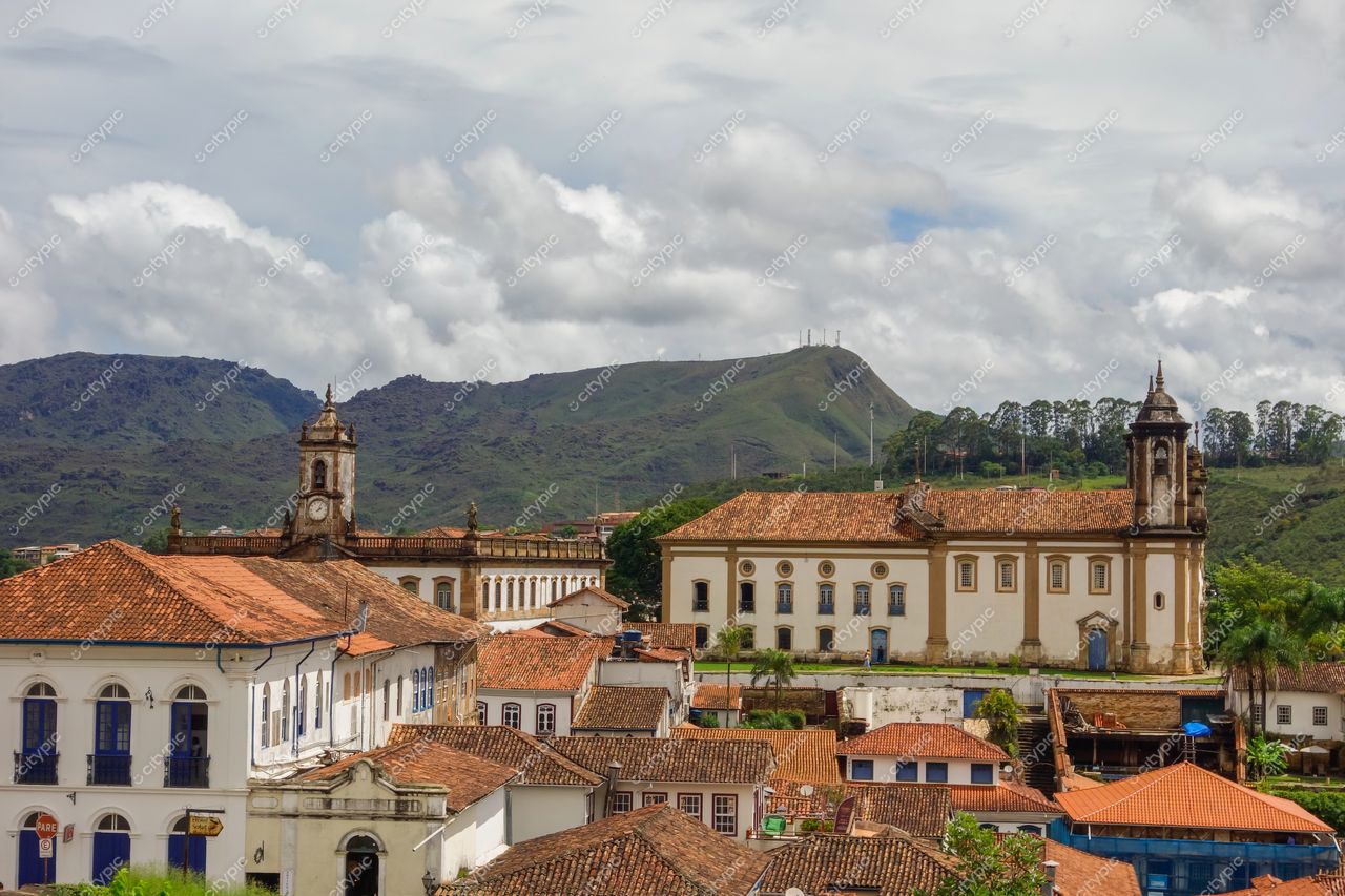 Ouro Preto, Minas Gerais com vista panorâmica da arquitetura colonial e montanhas sob céu nublado e vegetação nas encostas