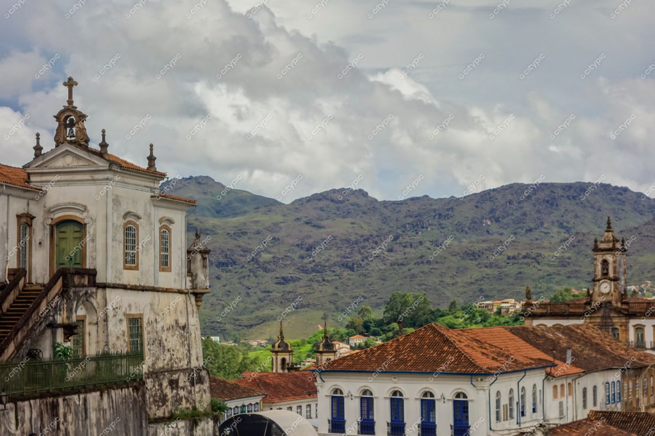 Ouro Preto, Minas Gerais, vista panorâmica com igreja colonial, montanhas verdes e céu nublado em iluminação suave
