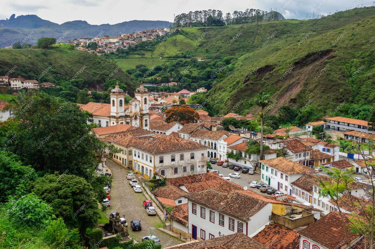 Ouro Preto, Minas Gerais com arquitetura colonial e vegetação densa sob iluminação nublada em dia chuvoso