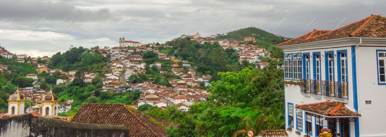 Ouro Preto, Minas Gerais, vista panorâmica com colinas, arquitetura colonial e vegetação exuberante sob céu nublado