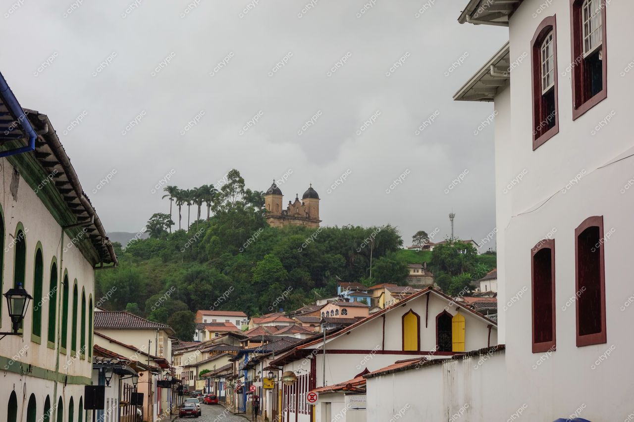 Mariana, Minas Gerais vista em dia nublado com colina, construção emblemática e casas coloniais coloridas