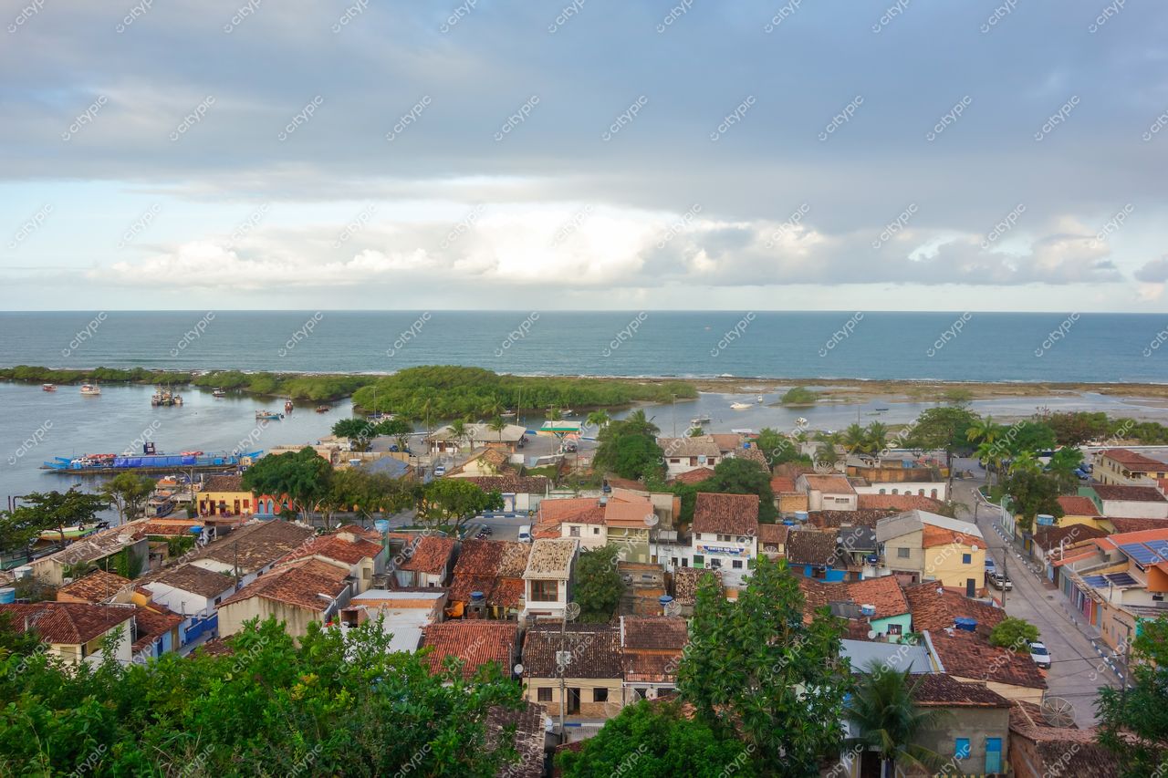 Santa Cruz Cabrália, Bahia, vista aérea com telhados coloridos, ruas tranquilas e vegetação vibrante à beira-mar