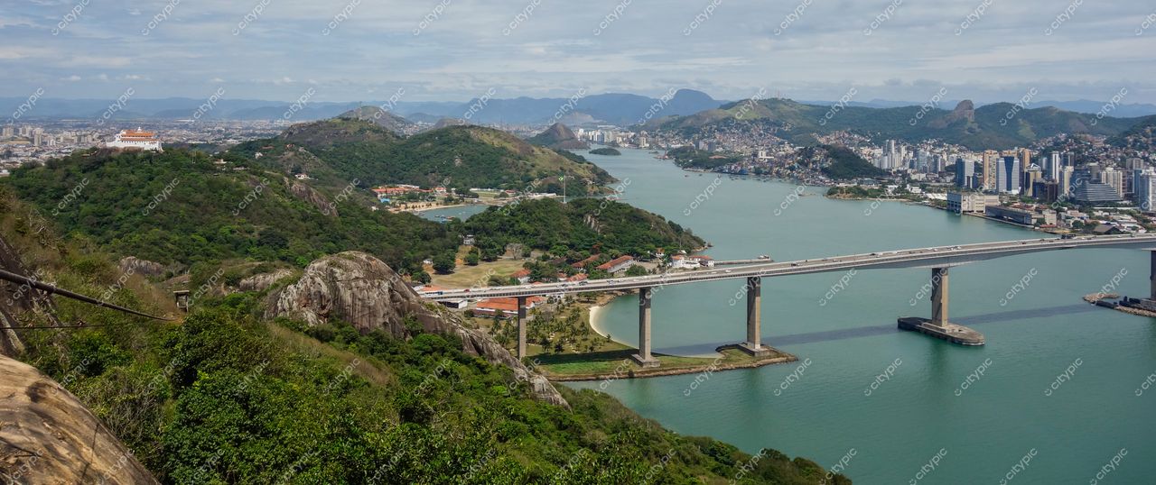 Vitória, Espírito Santo, vista panorâmica em dia ensolarado com montanhas verdes e interseção urbana à direita