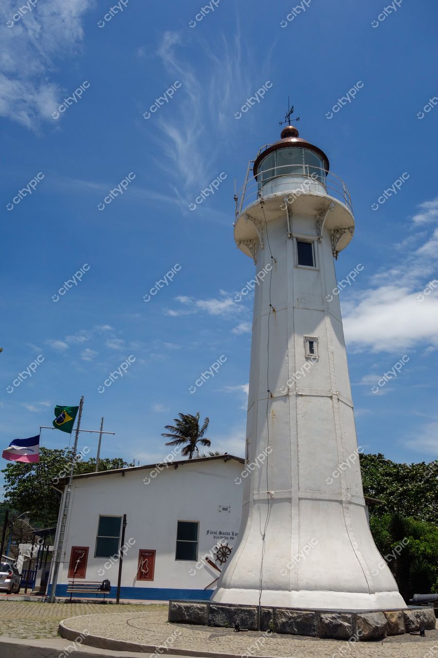 Vila Velha, Espírito Santo, farol branco com cúpula metálica e construção branca ao fundo em dia ensolarado
