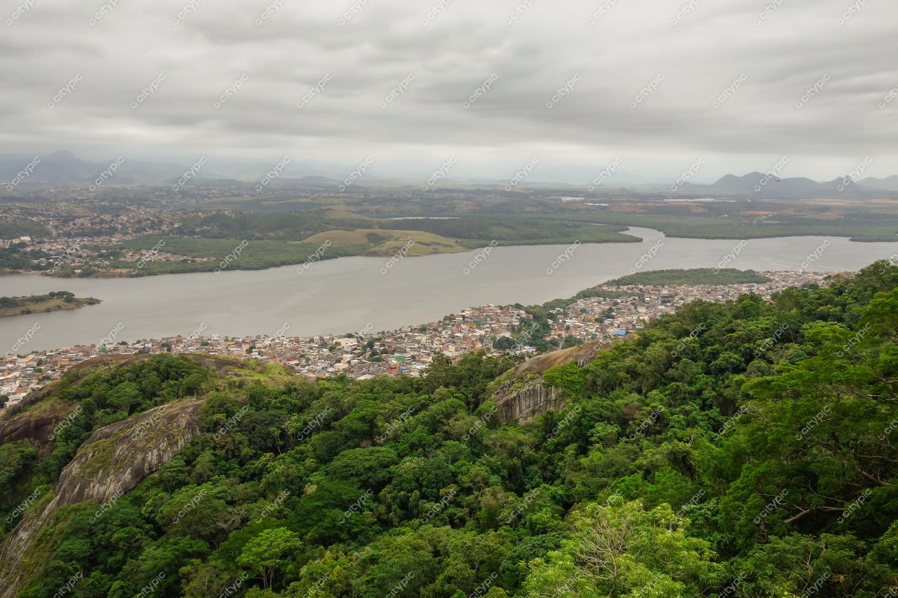Vitória, Espírito Santo, vista panorâmica com vegetação densa e lago refletindo céu nublado em área urbana tranquila