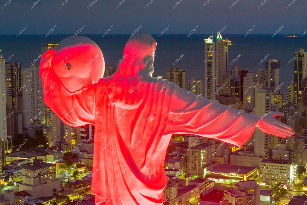 Balneário Camboriú, Santa Catarina, vista noturna com Cristo Redentor iluminado em vermelho e prédios altos ao fundo