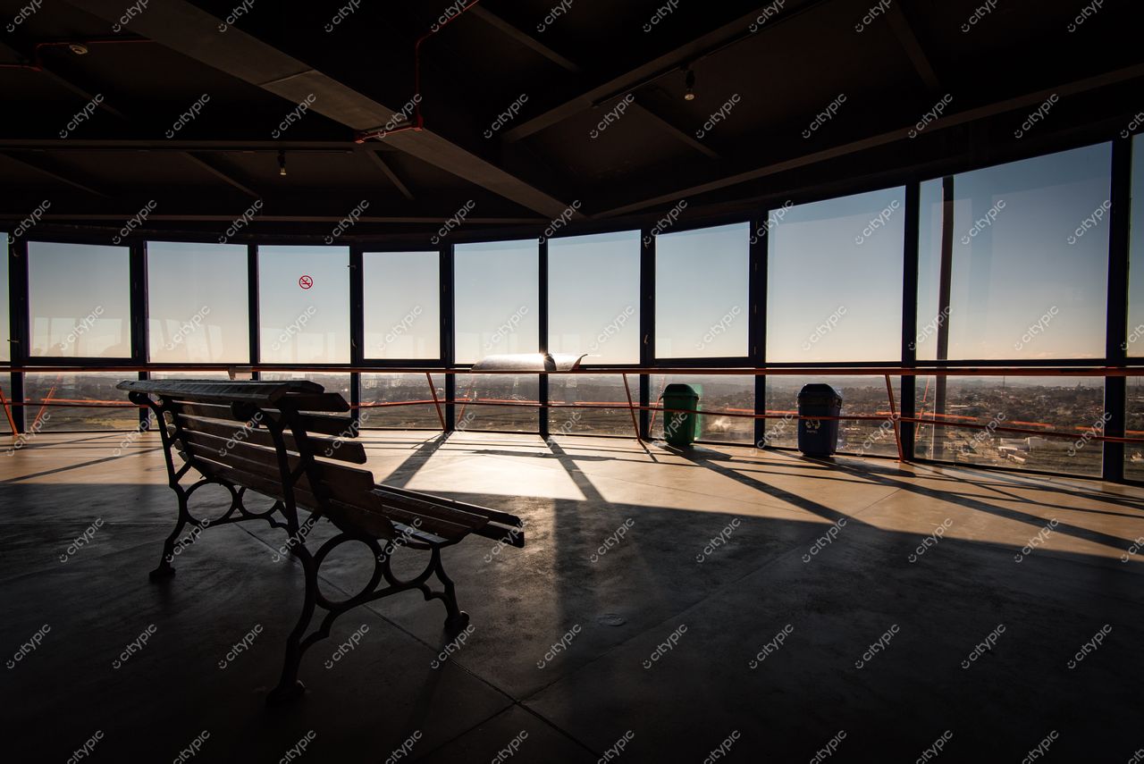 Curitiba, Paraná, interior de mirante moderno com luz do sol nascente e vista urbana através de grandes janelas