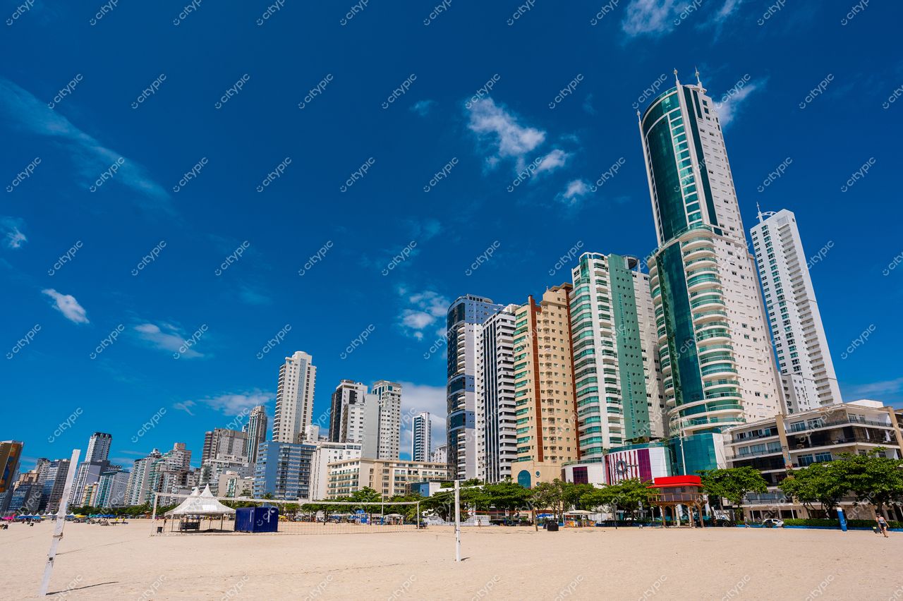 Balneário Camboriú, Santa Catarina, vista do litoral com prédios altos, céu azul e áreas verdes à beira-mar