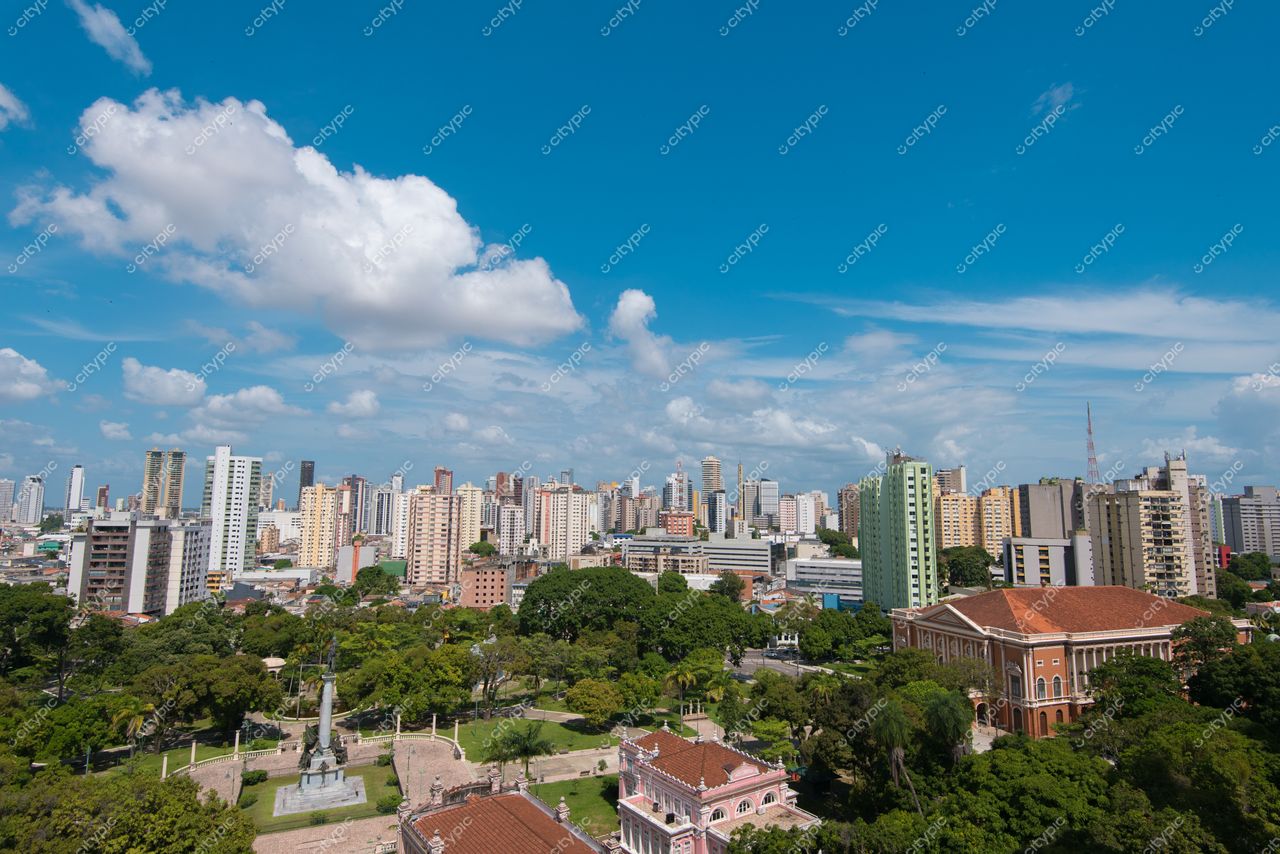 Belém, Pará com céu azul claro e nuvens, vista panorâmica de edifícios altos e vegetação ao redor