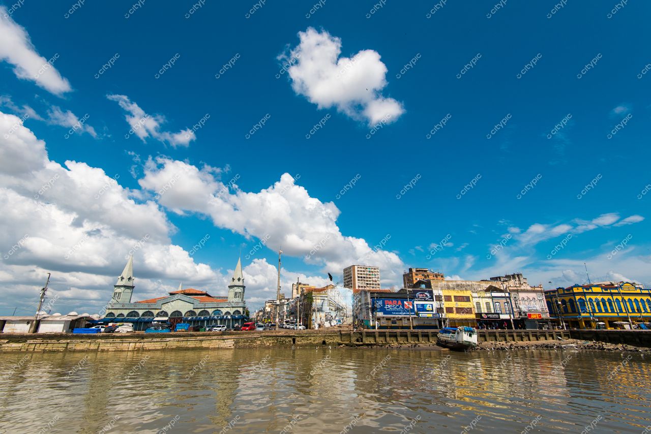 Belém, Pará com vista do rio e edifícios coloridos sob céu azul e nuvens brancas durante o dia