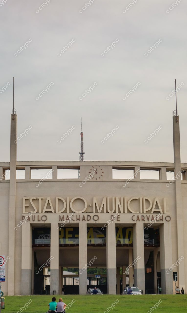 Estádio do Pacaembu em São Paulo com fachada modernista iluminada sob céu claro e grama verde à frente
