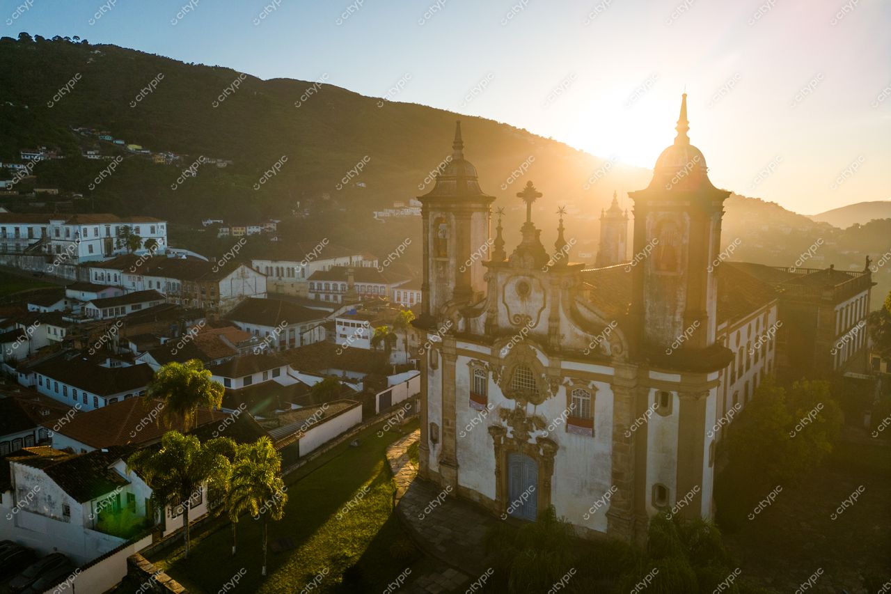 Ouro Preto, Minas Gerais ao amanhecer com luz suave destacando a arquitetura colonial e vegetação nas montanhas