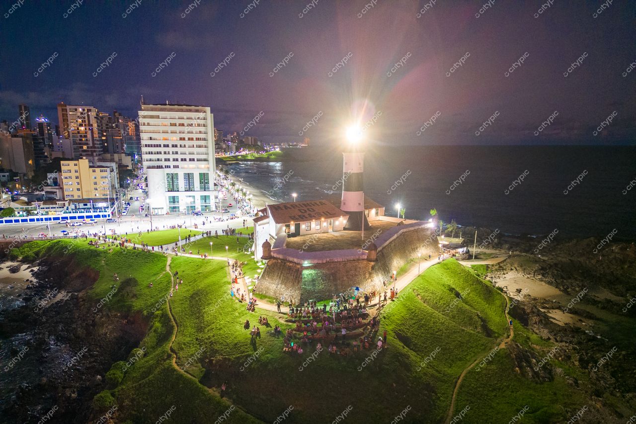 Salvador, Bahia panorama noturno do Farol da Barra com luzes urbanas e movimentação nas ruas à beira-mar