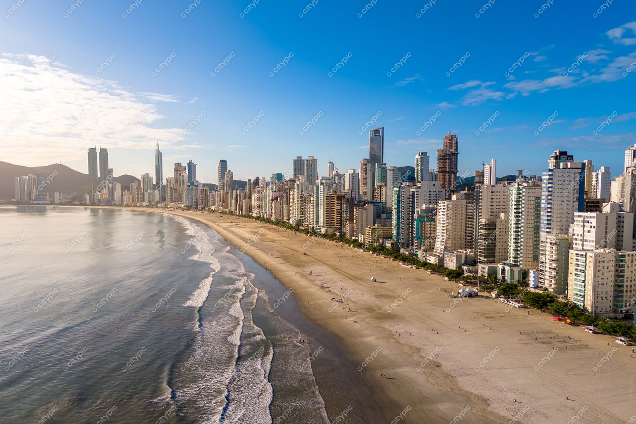 Balneário Camboriú, Santa Catarina vista panorâmica da praia com edifícios modernos e montanhas ao fundo em dia ensolarado