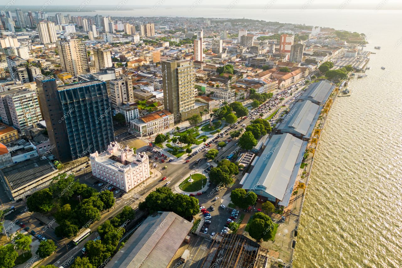 Belém, Pará vista panorâmica do calçadão à beira do rio com vegetação e edifícios modernos ao entardecer