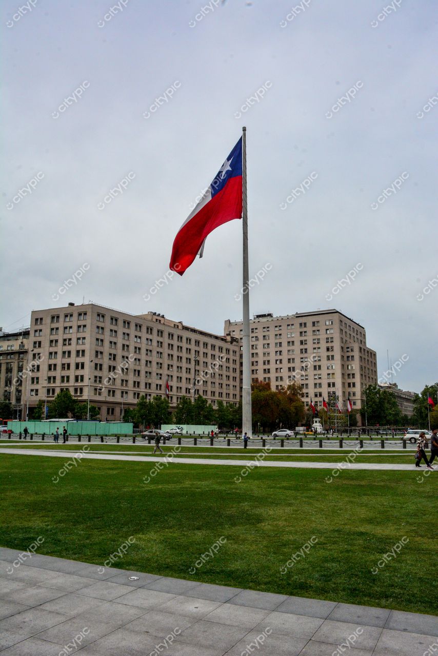 Plaza de la Ciudadanía, Santiago com bandeira chilena ao centro em dia nublado e iluminação suave, pessoas caminhando