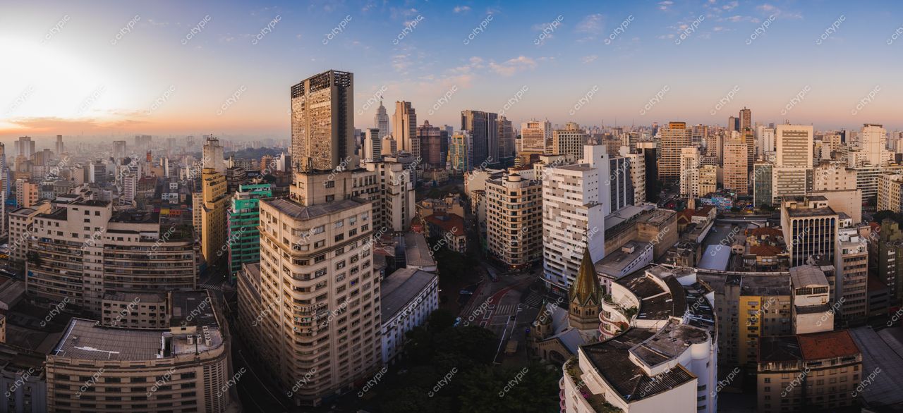 São Paulo, São Paulo ao amanhecer com luz suave destacando a arquitetura variada e ruas movimentadas entre prédios