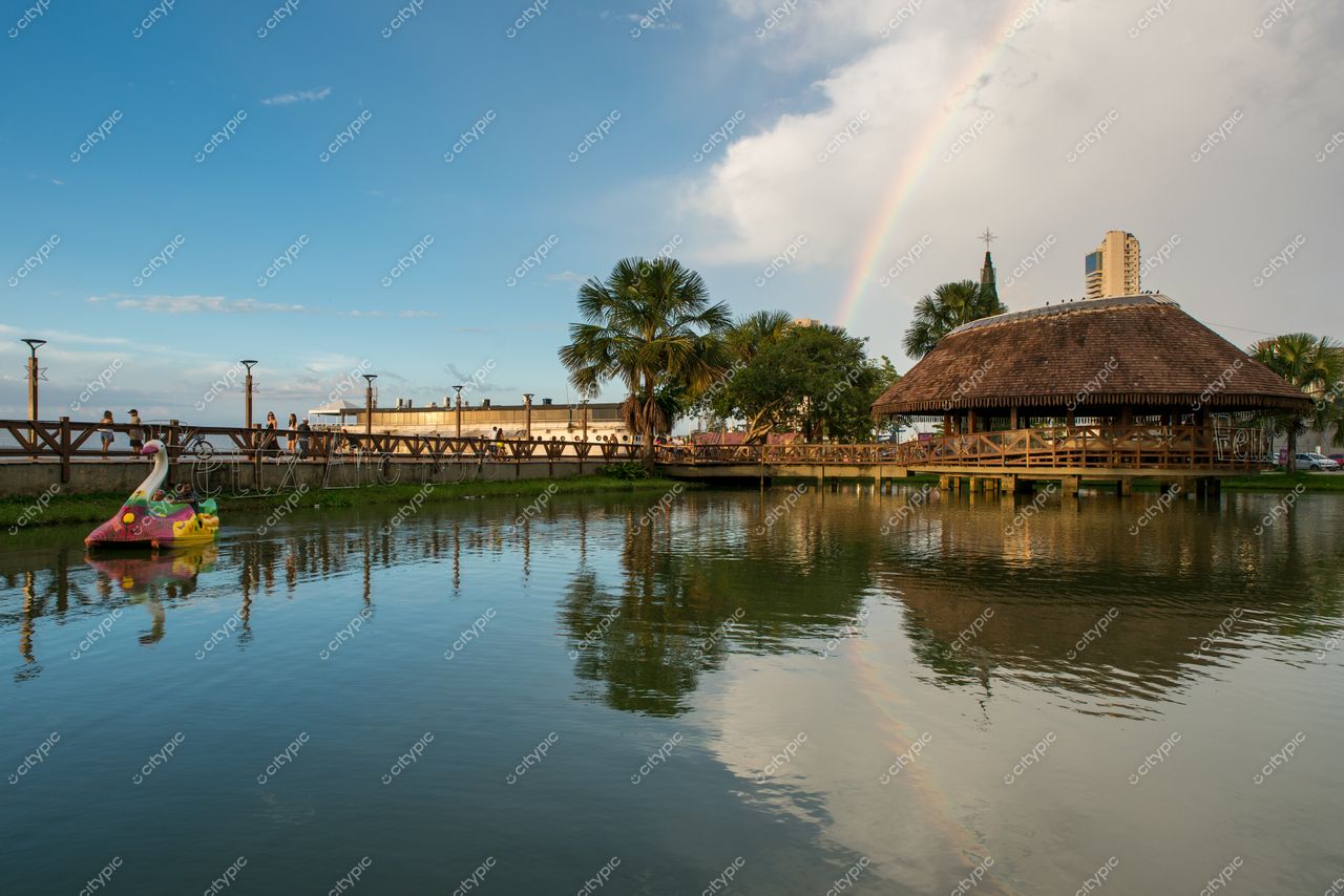 Belém, Pará, lago calmo com pedalinho cisne e construção de telhado de palha cercada por vegetação tropical