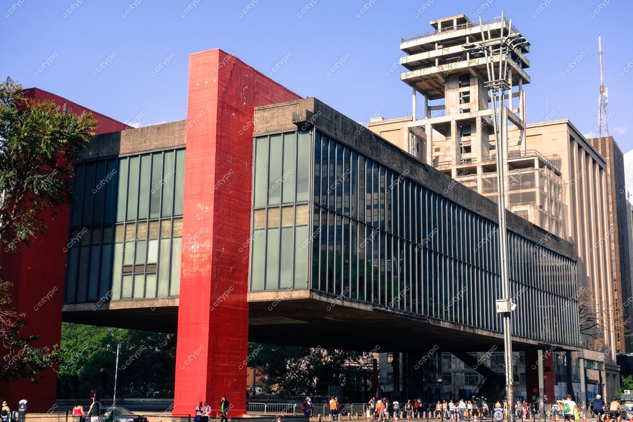 MASP – Museu de Arte de São Paulo com arquitetura modernista e vegetação ao fundo em dia ensolarado e movimento urbano